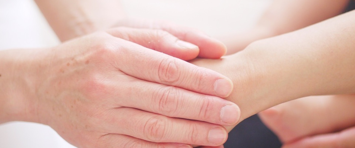 Image of two people holding hands