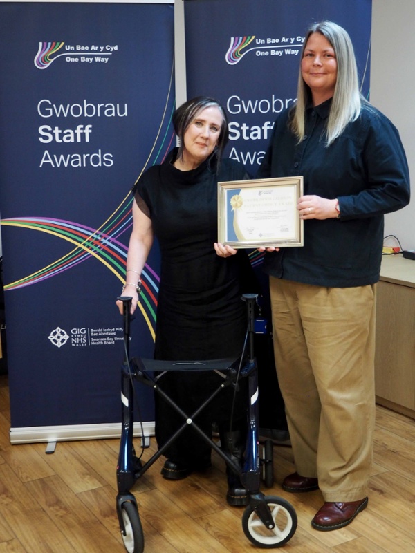 Maura Walsh and Julia stand together holding the Patient Choice Award certificate.