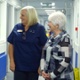 Image shows a group of people talking in a hospital corridor.