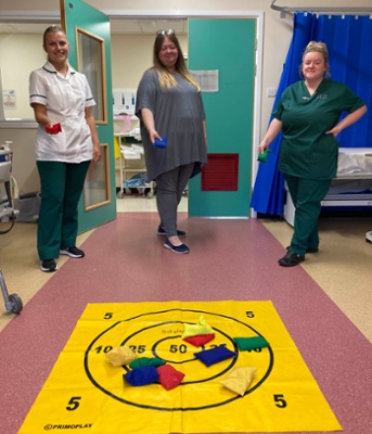 Image shows three women holding bean bags