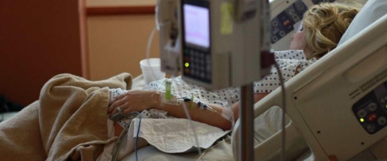 A patient in a hospital bed linked to machines.
