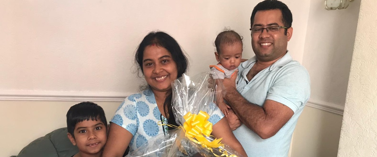 A happy mum and dad with their children and the hamper.