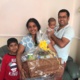 A happy mum and dad with their children and the hamper.