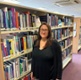 Image shows a woman standing in a library