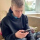 Image shows a teenager using his mobile phone