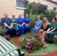 Image shows a group of people sitting in a garden