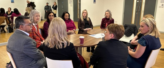 Health board staff sat around a table with the Minister