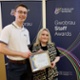 Image shows David and Jemma holding an award certificate and smiling