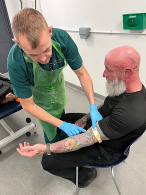 Image shows a man attending to a patient