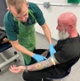 Image shows a man attending to a patient