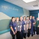 A group of midwives standing in front of a large wall mural