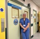 Image shows a woman standing in a hospital corridor