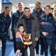 Image shows a group of people standing with a child