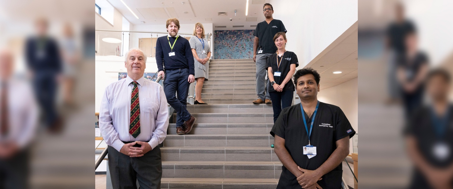 Image shows hospital research team members posing on stairs.