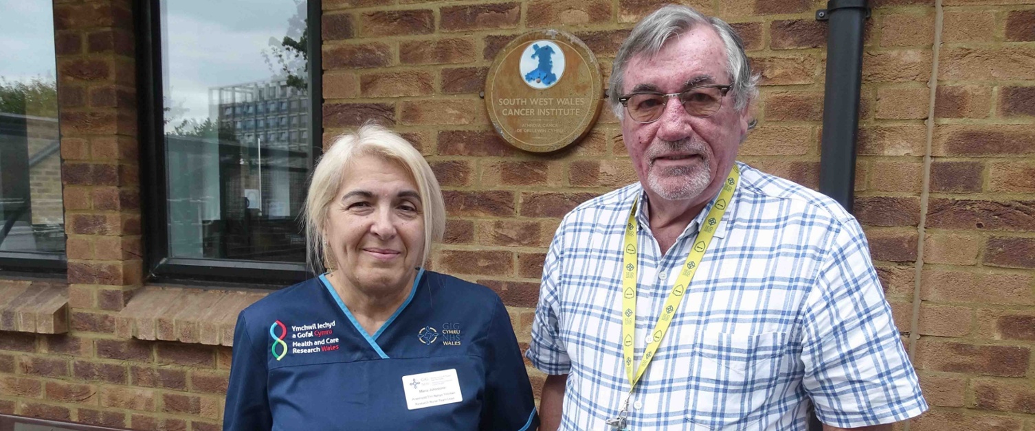 Image shows two people outside a hospital building.