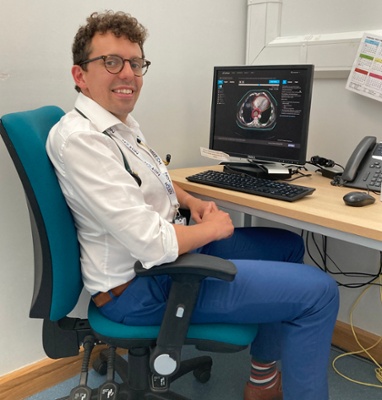 Image shows a man sat in front of a computer