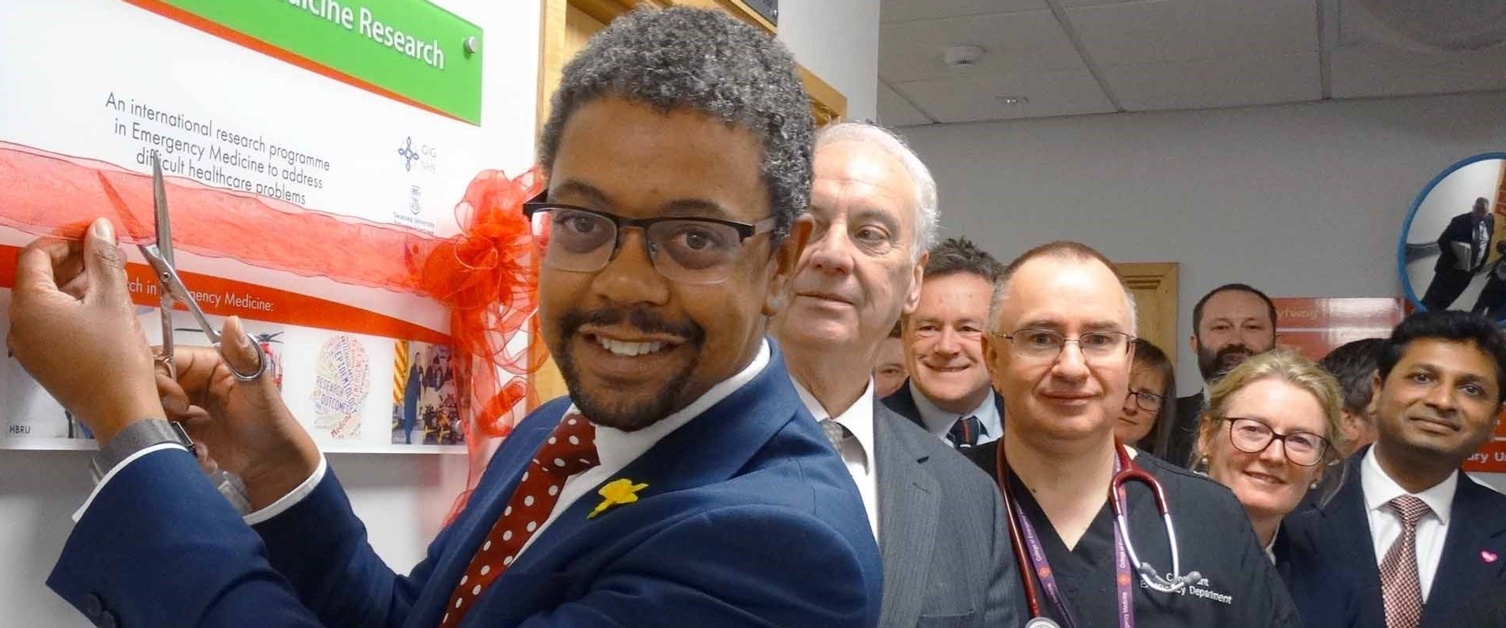 Health Minister Vaughan Gething smiling with members of staff opening a new centre at Morriston.