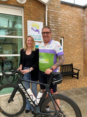 Image shows a woman and man standing behind a bicycle