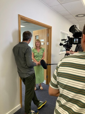 Image shows a woman being interviewed by a man