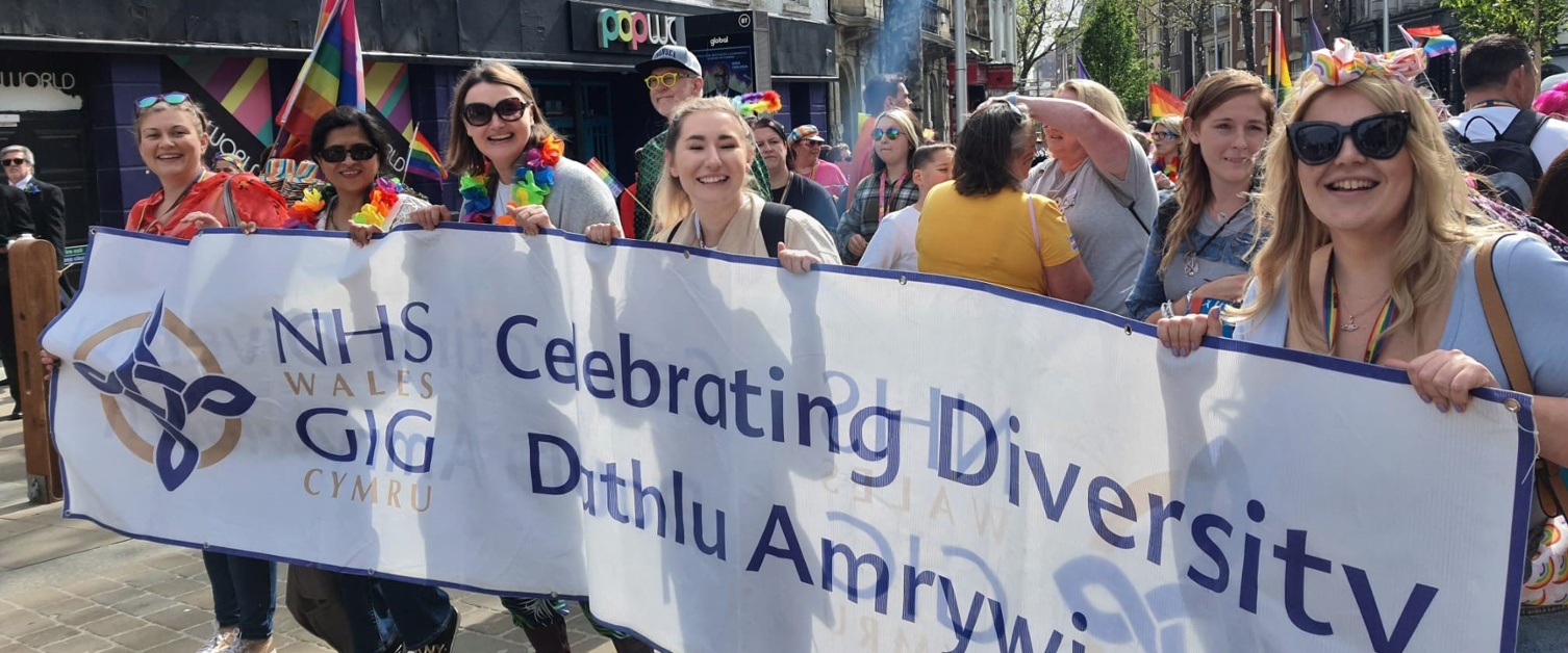 Members of staff marching in a pride event
