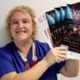 Carly is holding up posters advertising testing for syphilis