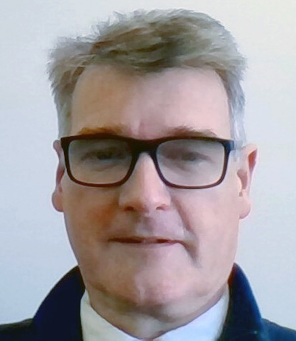 A headshot of a man wearing glasses