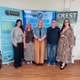 Sowndarya, Sharlene, Alex, Ian a Dawn yn sefyll o flaen baneri Clwstwr Penderi a CREST