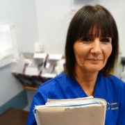 A nurse holding a file in a hospital waiting room