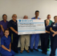 Dan danino ward team holding cheque