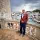 David yn sefyll ar falconi ar wyliau