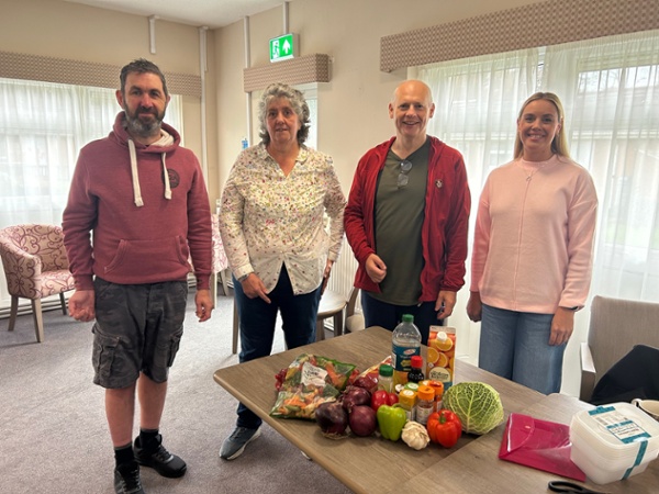 Nick, Julie, Alan ac Emma yn sefyll o flaen bwrdd gyda llysiau