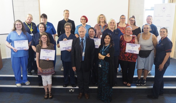 A group of patients and hospital staff, pictured with their certificates