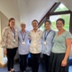Aelodau staff yn sefyll mewn practis meddyg teulu