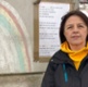 Woman facing camera with a chalk rainbow in the background