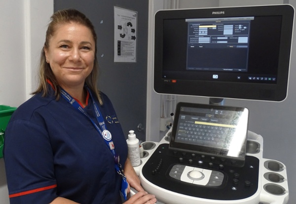 Hayley yn sefyll wrth ymyl sgrin