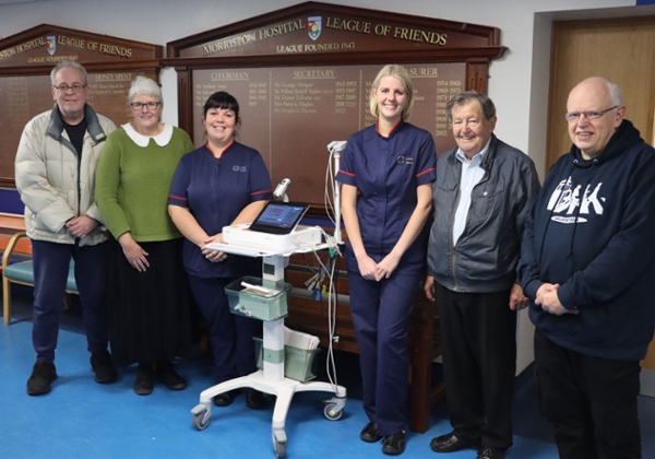 Roedd nyrsys a grŵp o gasglwyr elusennau yn sefyll wrth ochr peiriant ECG