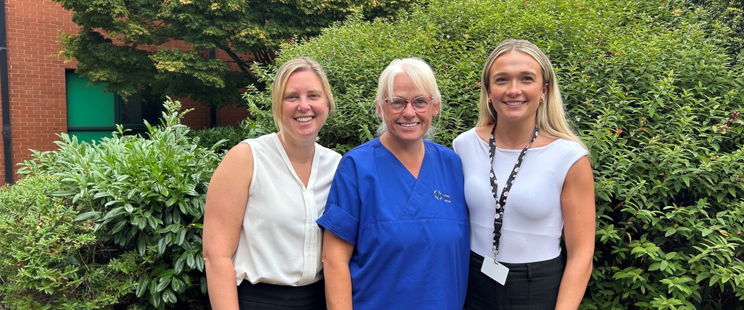 Andrea, Nicola a Lucie yn sefyll mewn gardd