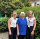 Andrea, Nicola a Lucie yn sefyll mewn gardd