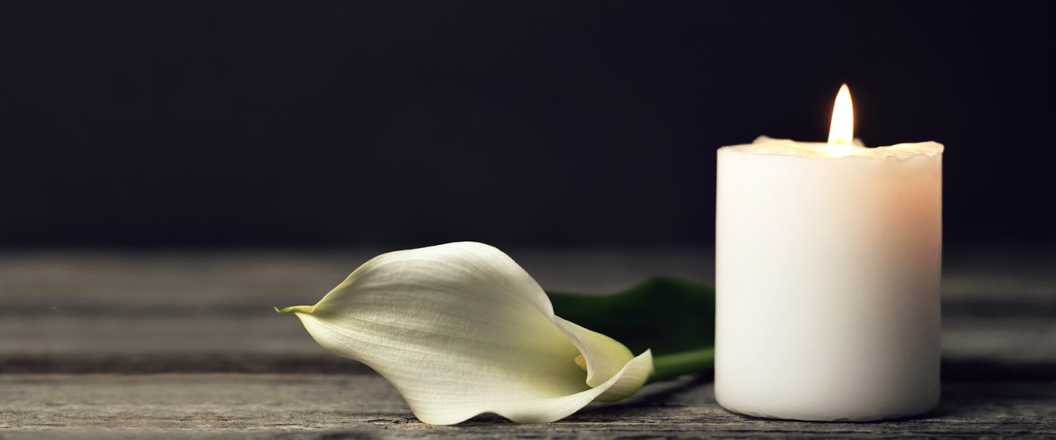 Image shows a candle and a flower.