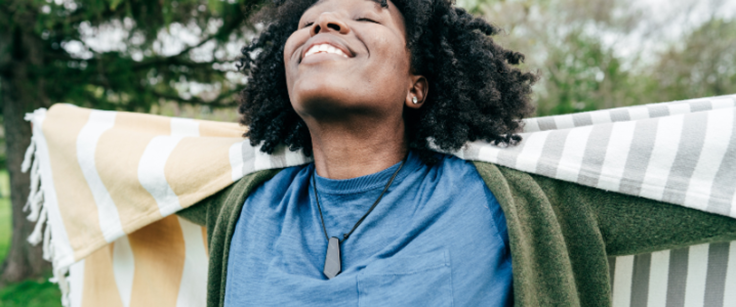 A woman facing the sky with arms outstretched.