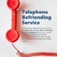 A promotional poster for the Telephone Befriending Service showing a red telephone handset on a grey background.