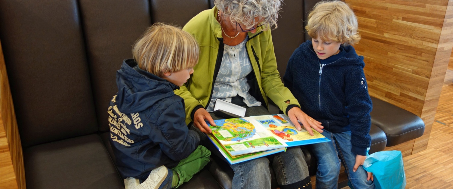 Image of a woman reading to two children.
