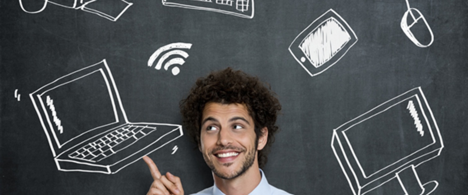 Man in front of blackboard with drawings of technology - laptop, wifi, keyboard, tablet