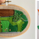 A photograph of Pistyll Rhaeadr by Stephen Thomas, an embroidery depicting countryside by Dr Nichola Norman, and a mixed media artwork by Joanna Waring