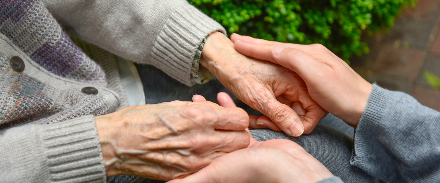 older person and younger person holding hands