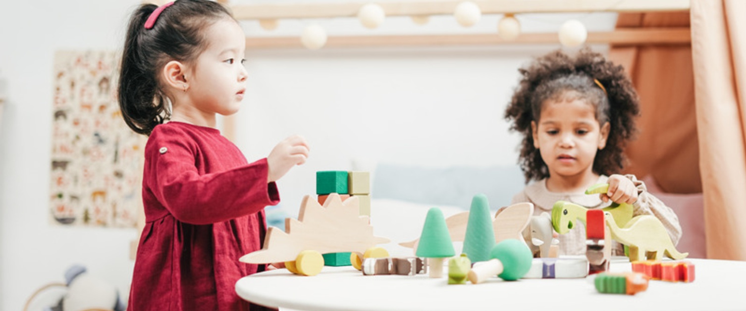 Two children playing with wooden blocks