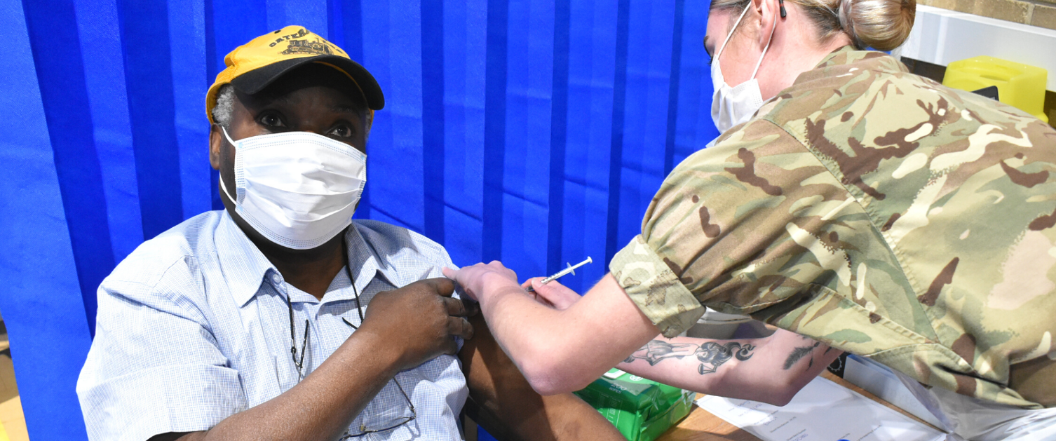 Picture of a military person giving a vaccination.