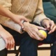 Elderly man holding a ball sat next to a younger woman