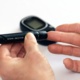 Person holding a black blood glucose monitor.