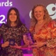 Jon, Katie, Lauren and Anne with awards - backdrop reads 